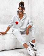 Model purtând trening Ema gri cu hanorac și inimioară brodată, ținută casual sport pentru confort zilnic